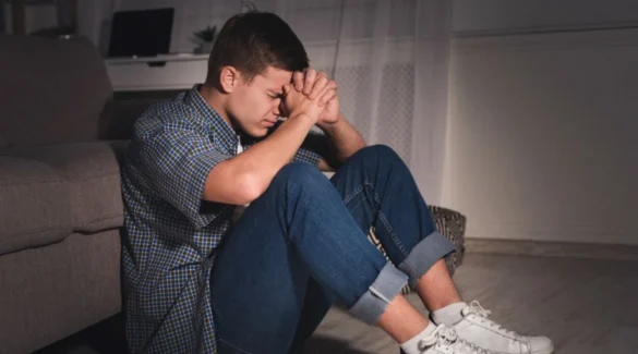 Image of a teen sitting on the floor with hands on his face - 11+ Household Items Teens Get High On