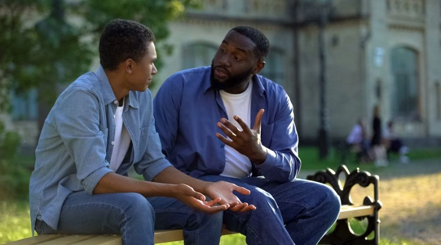 Image of a father talking to his son on a park bench - Conversations about meth addiction