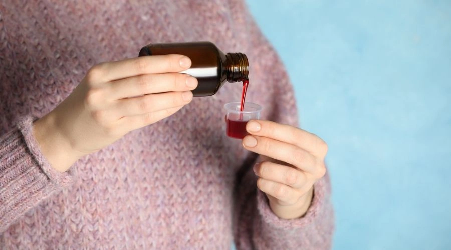 Image of cough syrup being poured in a cup - Cough Syrups Addiction