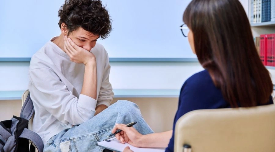 Image of a female teenager sitting in therapy with her female counselor - Dialectical behavior therapy for teens