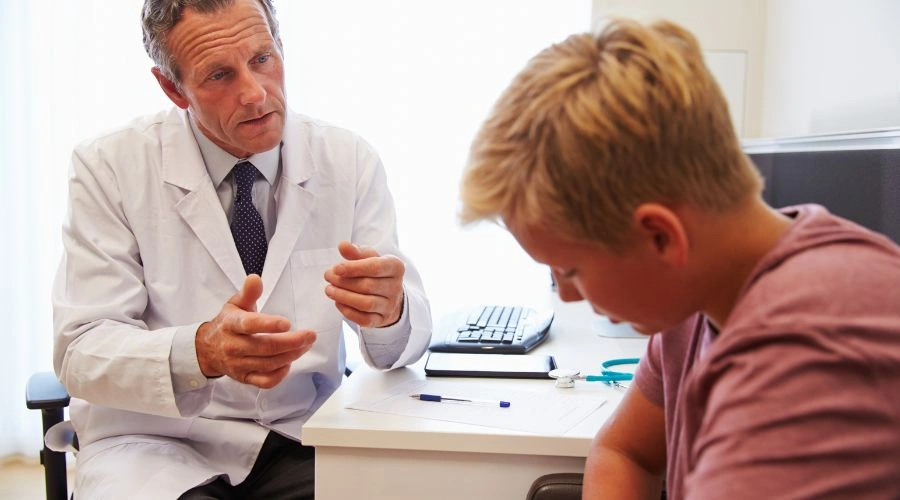 Image of a doctor consulting with a teenage male suffering with schizophrenia