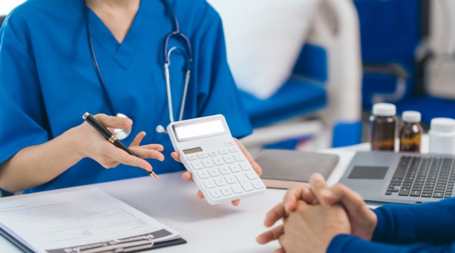 Image of physician's medical staff explaining cost of teen BPD and treatment options, holding a calculator in one hand