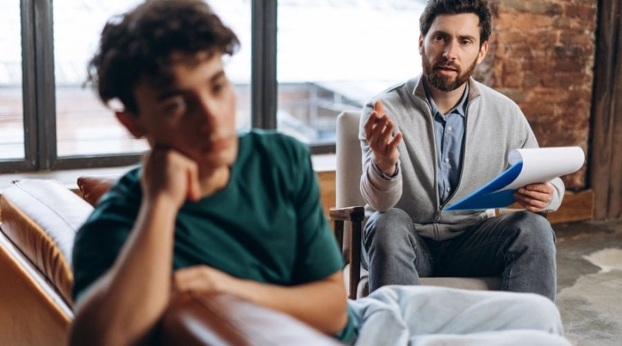 Image of distraught teen in treatment speaking to a counselor - Teen Cocaine Addiction Treatment