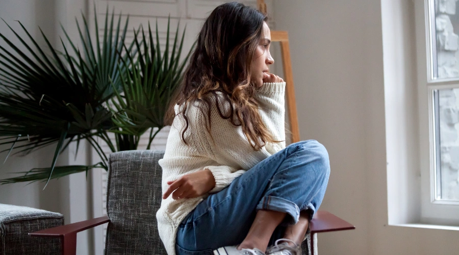 Image of a depressed teenage girl sitting on chair feeling broken and lonely