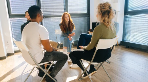 Image of teen participating in a Narcotics Anonymous meeting, listening to peers share experiences with addiction and recovery