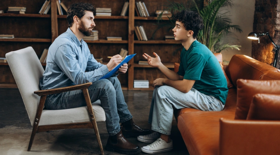 Image of a male teen talking with a counselor - Motivational Interviewing for Teens - Artemis Adolescent Healing Center