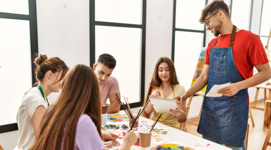 Image of a group of teens painting together during a creative therapy activity