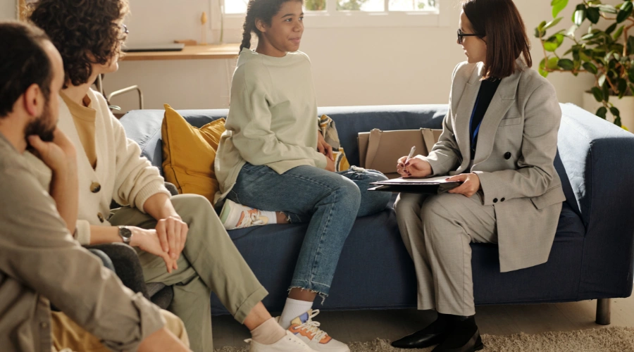 Image of a family and therapist sitting together, using communication exercises to teach teens positive coping skills and prevent risky behaviors