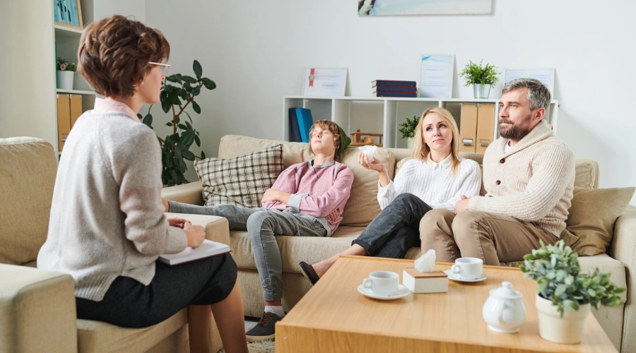 Image of a mother, father and their teen son sitting in therapy with a counselor - Multisystemic Therapy - Artemis Adolescent Healing Center