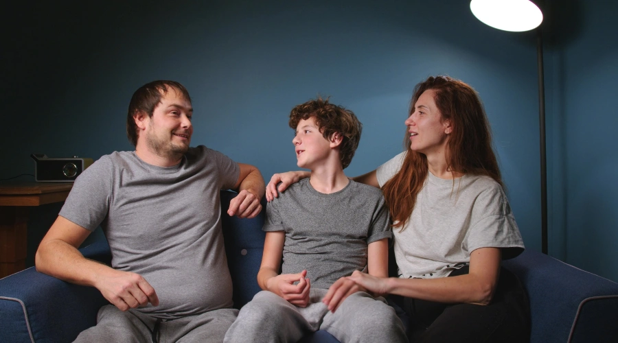 Image of a male teen and his parents talking openly about depression 