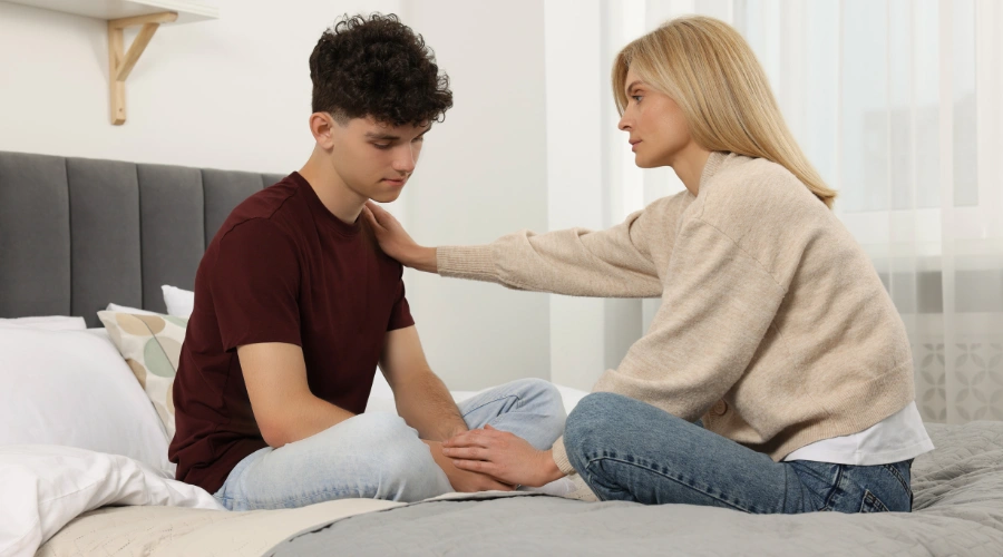 Image of a parent trying to console a depressed male teen - How to Tell Your Parents You're Depressed - Artemis Adolescent Healing Center