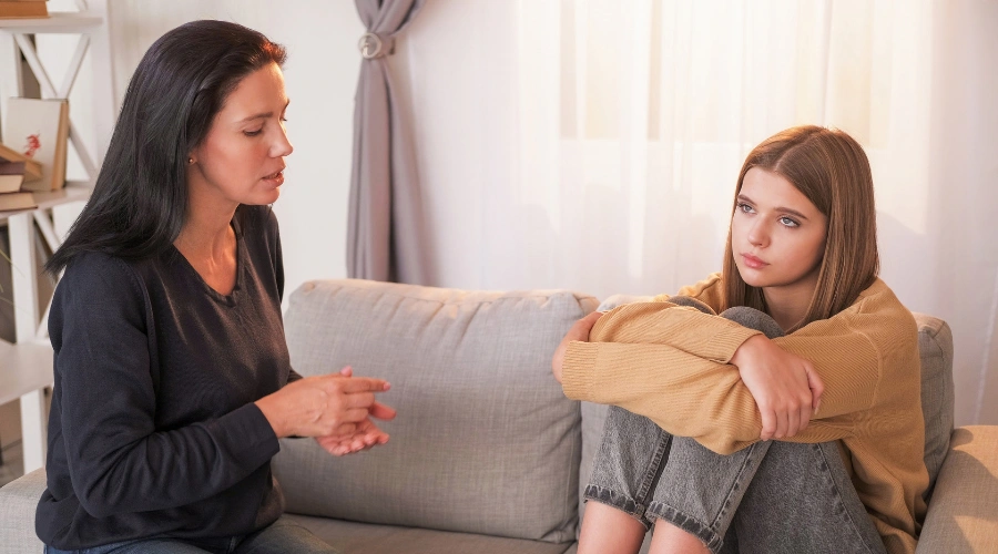 Image of Parent supporting teen with mental health challenges, addressing causes of aggression and youth violence at home