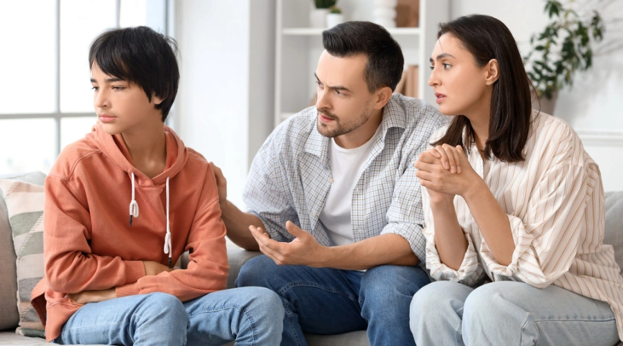 Image of a concerned mother and father talking with their teen son about his substance use