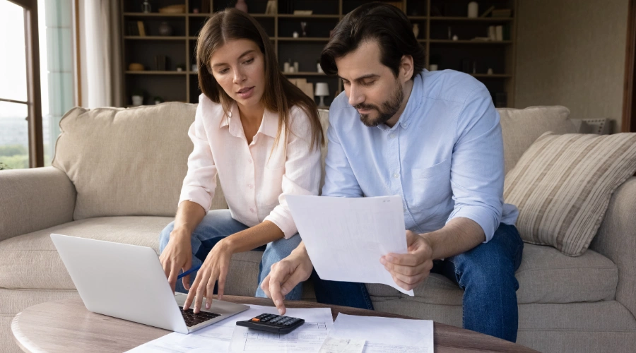 Image of a concerned parent reviewing medical bills and insurance paperwork at home