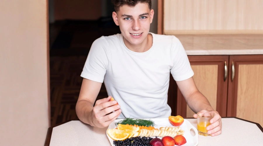 Image of a male teen eating a balanced meal to support mental health and recovery from eating disorders