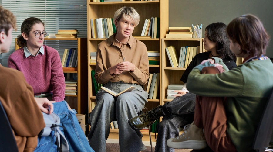 Image of adolescent participating in trauma-informed therapy with counselor, peer support, and family involvement