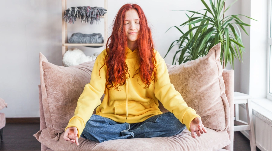 Image of a female teen practicing mindfulness to mental health challenges