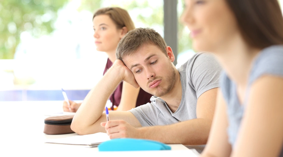 Image of a male teen with ADHD sitting in a classroom and not paying attention - ADHD Treatment for Teens - Artemis Adolescent Healing Center