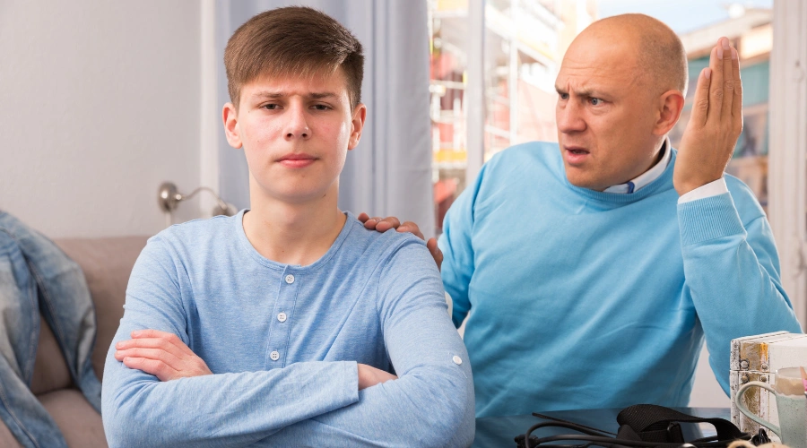 Image of an angry male teen beside his bewildered father - Addressing Passive Aggressive Behavior in Teens - Artemis Adolescent Healing Center