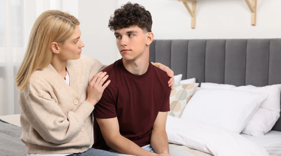 Image of a supportive parent gently encouraging a resistant teen to seek help for substance abuse treatment