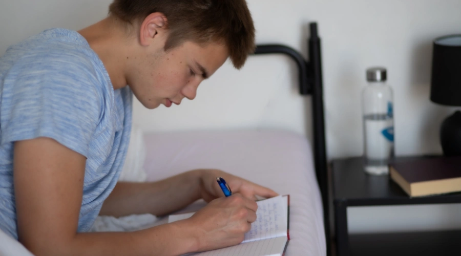 Image of a teenager practicing mindful writing and journaling as a therapeutic activity