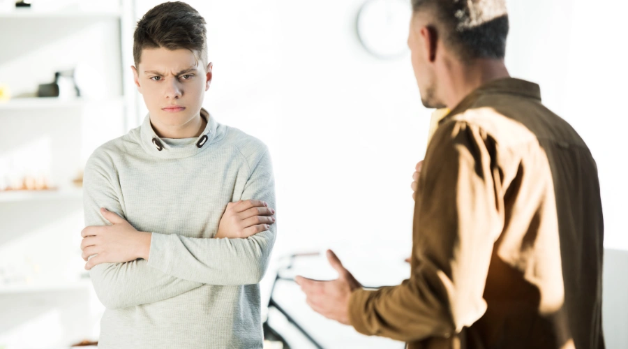 Image of an angry, defiant male teen listening to his father -Treating Oppositional Defiant Disorder in Teens - Artemis Adolescent Healing Center