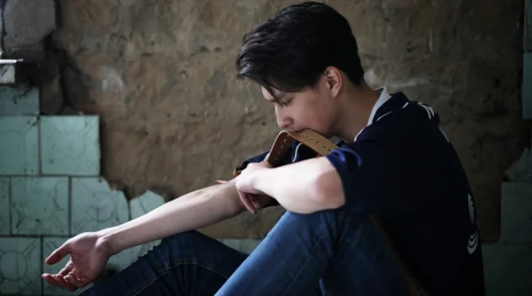 Image of a male teen "shooting up" a drug with a syringe - Why Do Teens Turn to Drugs - Artemis Adolescent Healing Center