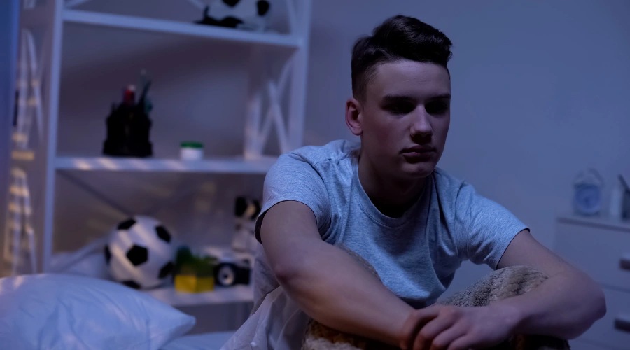 Image of a male teen sitting a home isolated in his bedroom - Antisocial Personality Disorder Treatment for Teens - Artemis Adolescent Healing Center