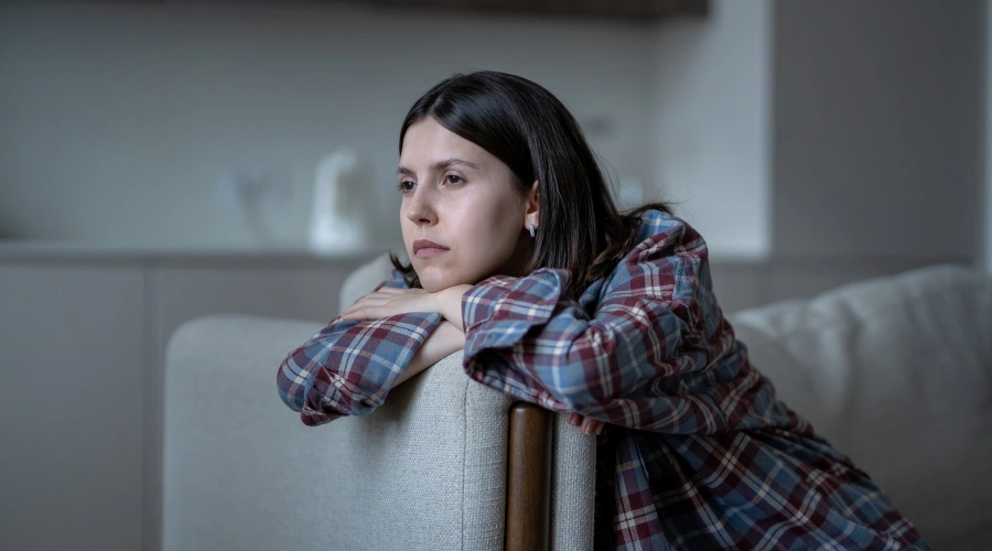 Image of a sad and withdrawn teenager sitting alone in a corner representing the emotional pain