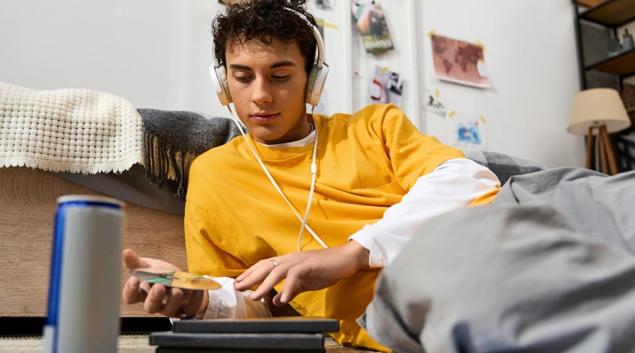Image of a teenager wrapped in a soft blanket listening to music in a comfortable, safe environment