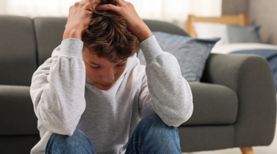 Image of an overwhelmed teen experiencing emotional distress that may trigger self-harm relapse